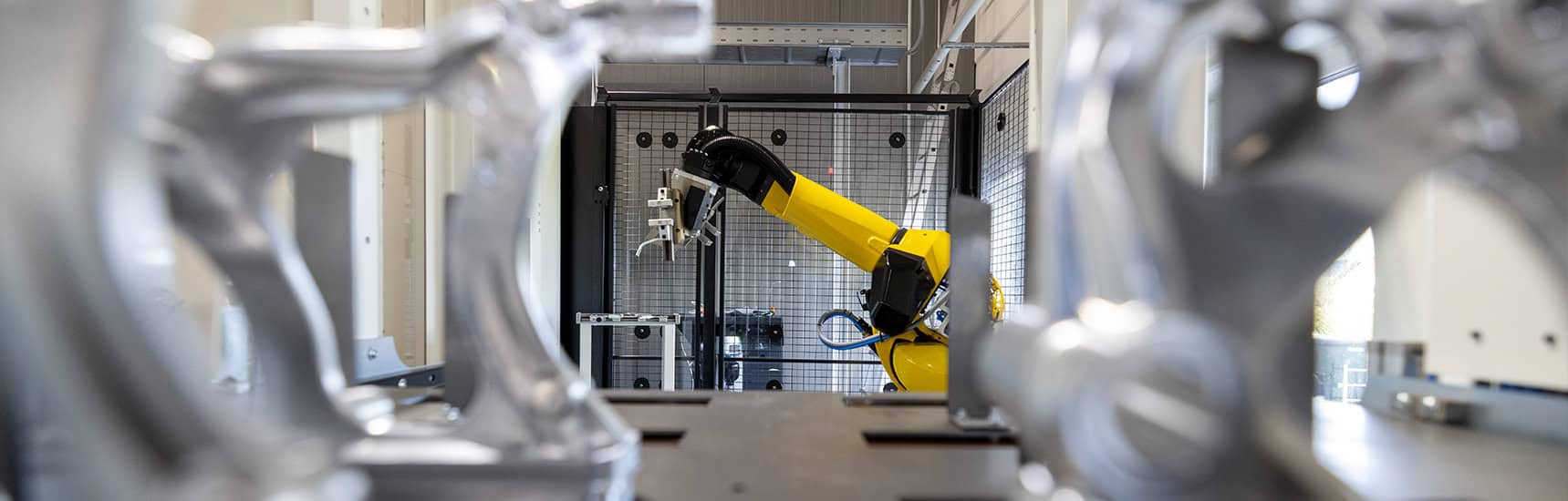 a yellow robot arm in a factory