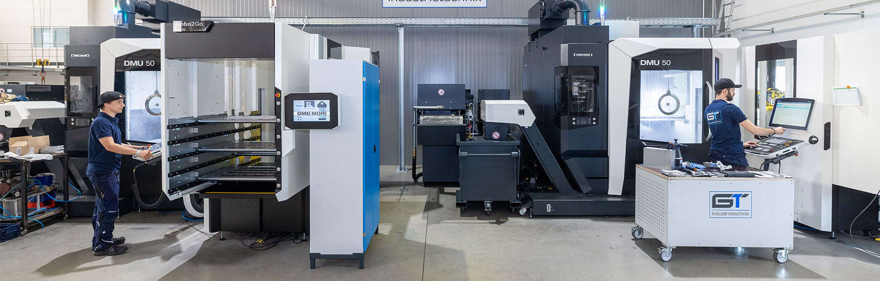 Zwei Männer arbeiten an einer CNC-Maschine.